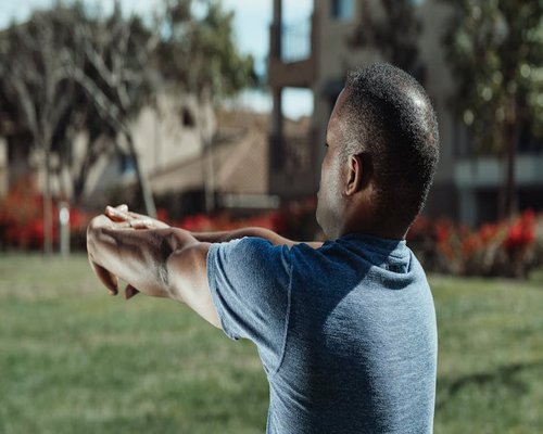Person doing light wrist and shoulder movements before exercise